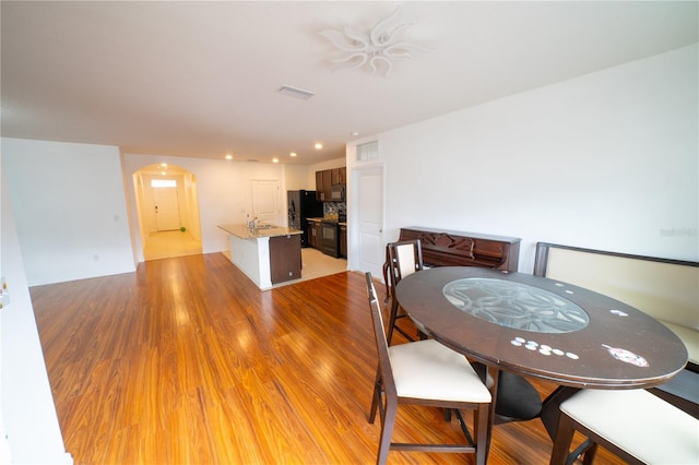 dining area with sink and hardwood / wood-style flooring