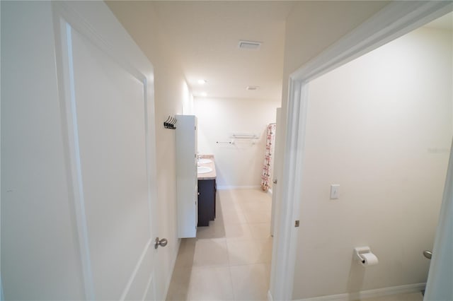 hall with light tile patterned floors