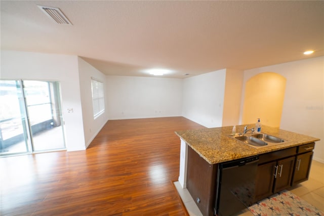 kitchen with sink, dark brown cabinets, a center island with sink, light hardwood / wood-style flooring, and dishwasher