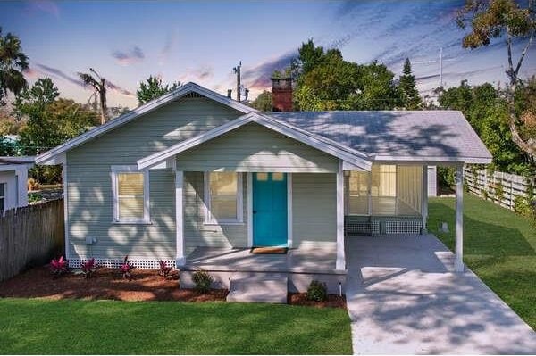 bungalow featuring a yard and a carport