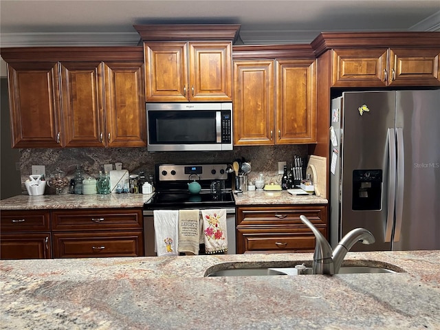 kitchen featuring stainless steel appliances, tasteful backsplash, light stone counters, and sink