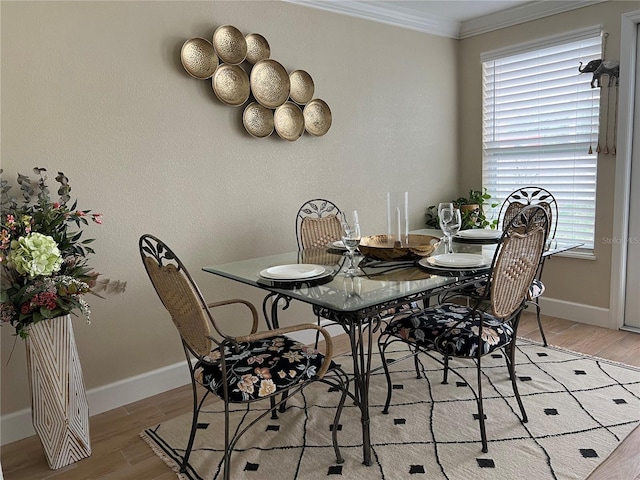 dining space with light wood-type flooring and crown molding