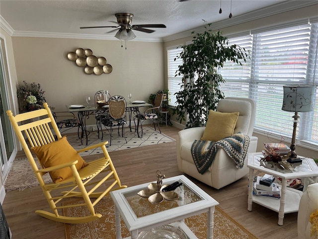 living room with ceiling fan, hardwood / wood-style flooring, crown molding, and a textured ceiling