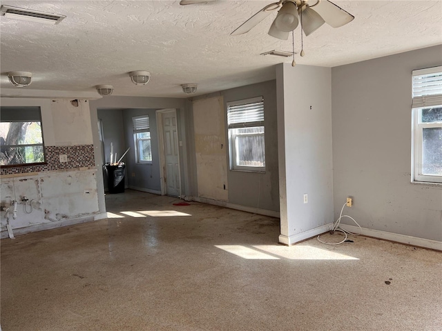 spare room with ceiling fan, a textured ceiling, and a healthy amount of sunlight