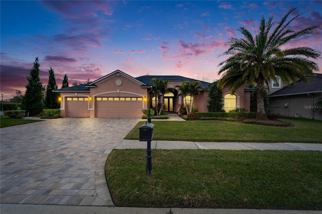 view of front facade with a garage and a lawn