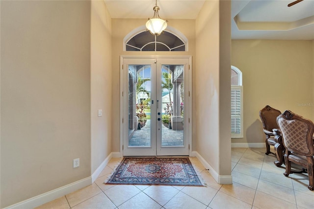 foyer with french doors, light tile patterned flooring, and baseboards