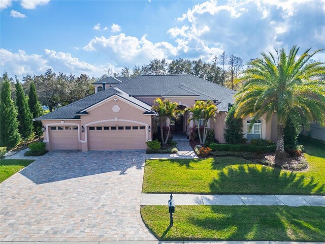 2903 Marble Crest Dr, Land O Lakes, FL 34638 - view of front of house featuring stucco siding, decorative driveway, a garage, and a front yard