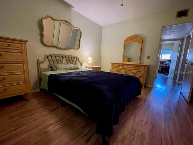 bedroom with vaulted ceiling and dark hardwood / wood-style floors