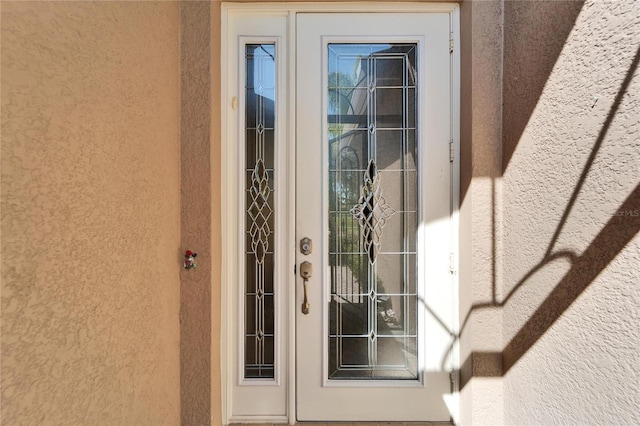 view of exterior entry featuring stucco siding