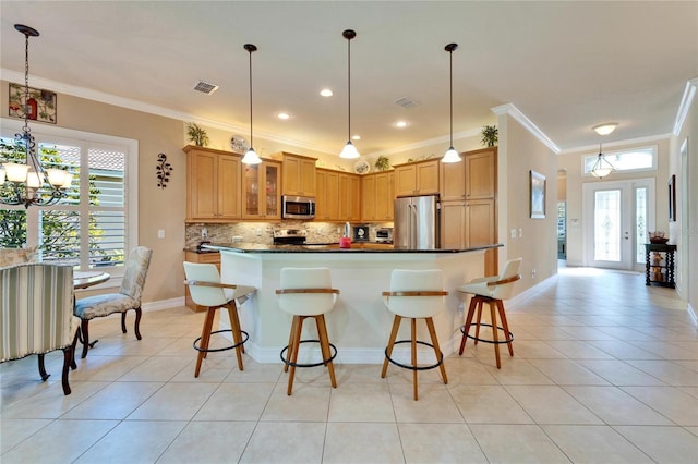 kitchen with light tile patterned floors, decorative backsplash, appliances with stainless steel finishes, dark countertops, and a wealth of natural light