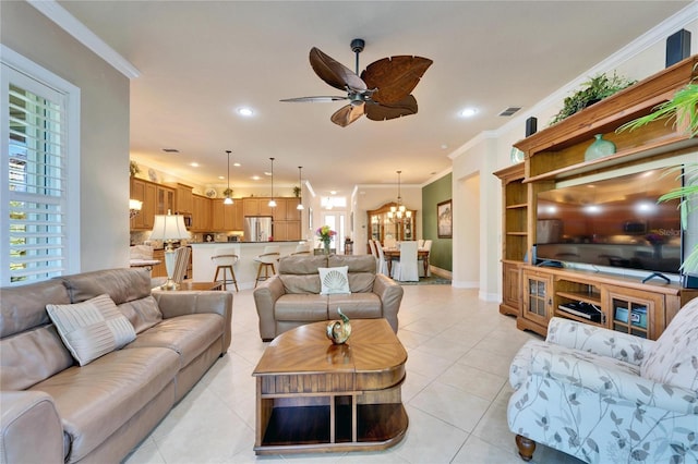 living area featuring light tile patterned floors, visible vents, ceiling fan with notable chandelier, and ornamental molding