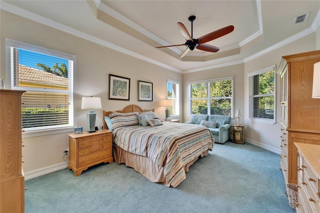 bedroom featuring a raised ceiling, multiple windows, visible vents, and light carpet