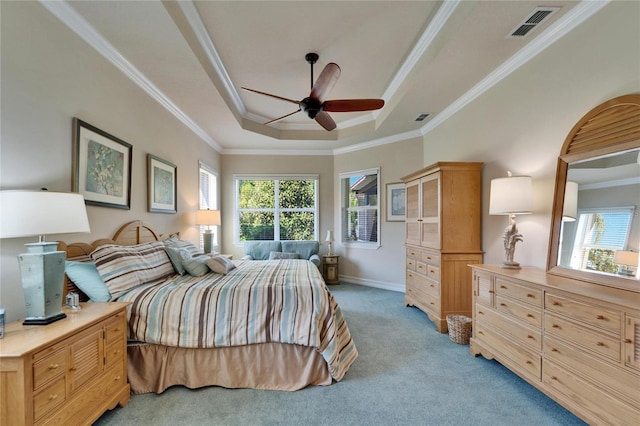 bedroom with a raised ceiling, multiple windows, visible vents, and light carpet