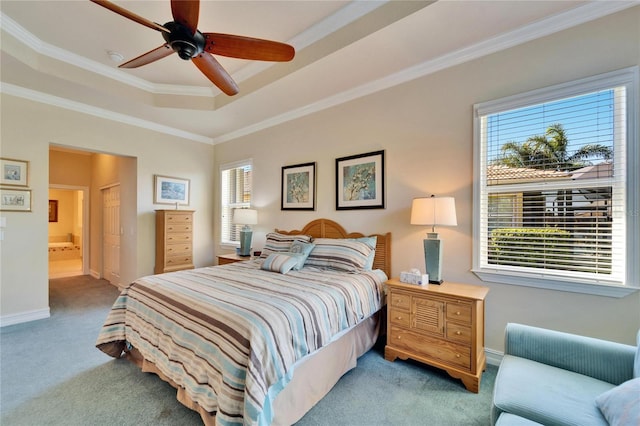 bedroom featuring light colored carpet, ensuite bathroom, a raised ceiling, and ornamental molding