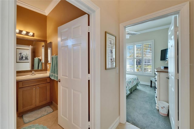 bathroom with tile patterned floors, baseboards, vanity, and crown molding