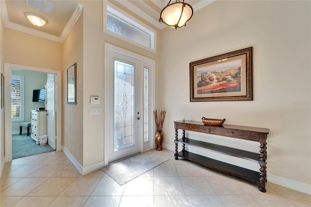 foyer entrance with light tile patterned floors, visible vents, baseboards, and ornamental molding