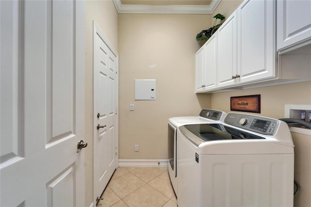 clothes washing area featuring ornamental molding, washer and clothes dryer, cabinet space, light tile patterned floors, and baseboards