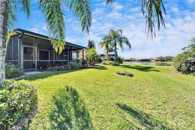 view of yard featuring a water view and a sunroom