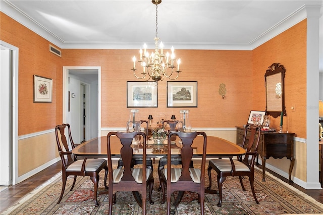 dining space featuring a wainscoted wall, a chandelier, and crown molding