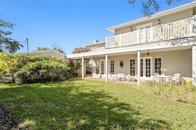 back of house featuring a balcony, a ceiling fan, french doors, stucco siding, and a patio area