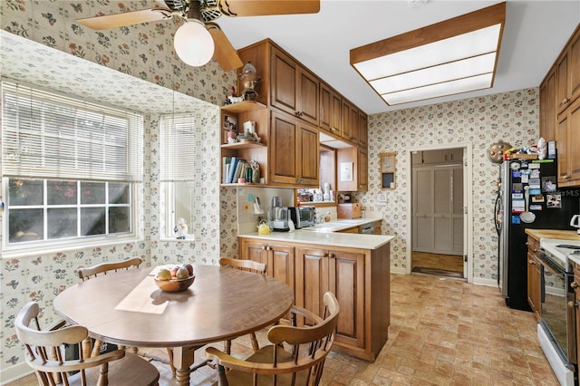 kitchen featuring brown cabinetry, light countertops, a peninsula, and wallpapered walls