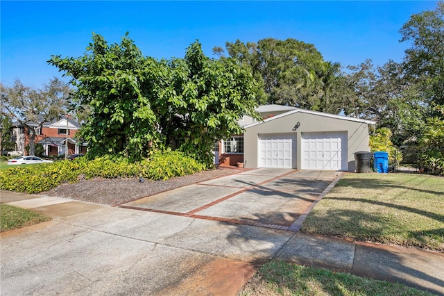 view of front of property featuring concrete driveway, a front lawn, an attached garage, and stucco siding