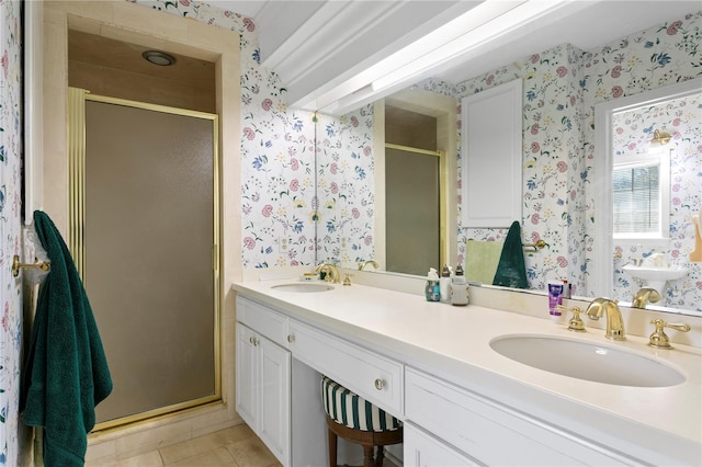 bathroom featuring double vanity, wallpapered walls, a shower stall, and a sink