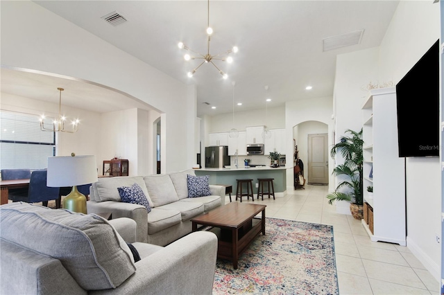 living room with light tile patterned flooring and a notable chandelier