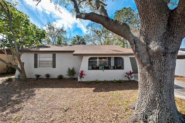 ranch-style home featuring an attached garage and stucco siding