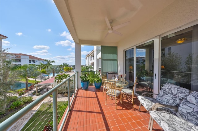 balcony with ceiling fan and a water view