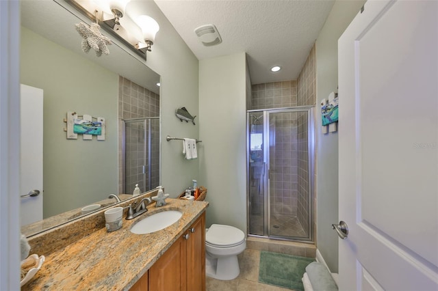 bathroom featuring tile patterned flooring, vanity, walk in shower, toilet, and a textured ceiling