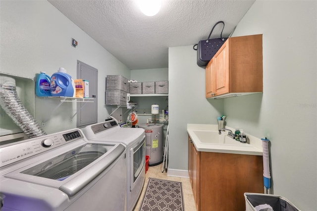 washroom with light tile patterned flooring, sink, cabinets, washer and dryer, and a textured ceiling