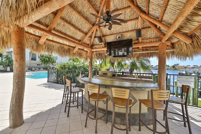 view of patio / terrace featuring a gazebo, ceiling fan, and exterior bar