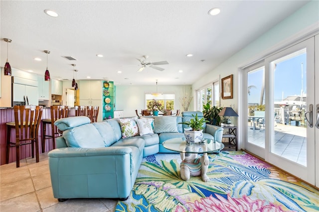 living room featuring ceiling fan, french doors, and a textured ceiling