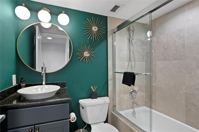 full bathroom with vanity, enclosed tub / shower combo, and toilet
