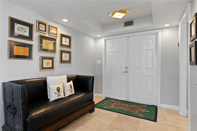 tiled entrance foyer featuring a tray ceiling