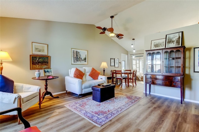 living room featuring ceiling fan, wood-type flooring, and high vaulted ceiling