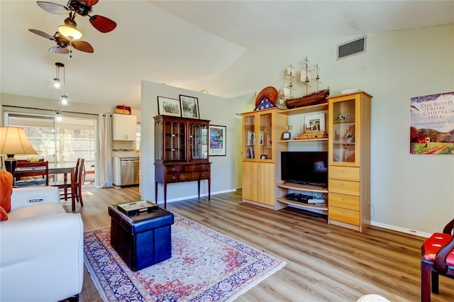 living room featuring light hardwood / wood-style flooring, vaulted ceiling, and ceiling fan