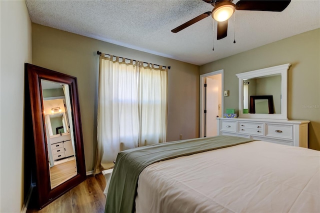 bedroom with ceiling fan, hardwood / wood-style floors, and a textured ceiling