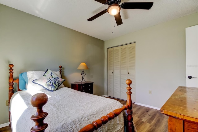 bedroom featuring ceiling fan, dark hardwood / wood-style floors, and a closet