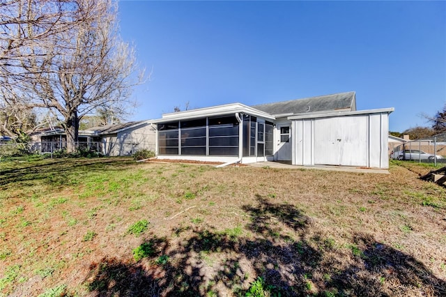 rear view of property with a sunroom and a yard