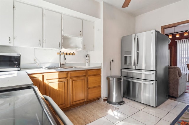 kitchen featuring light tile patterned flooring, appliances with stainless steel finishes, sink, white cabinets, and ceiling fan