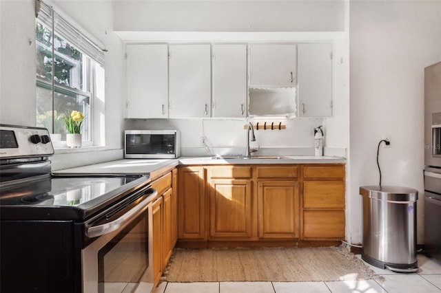 kitchen with stainless steel appliances, sink, and light tile patterned floors