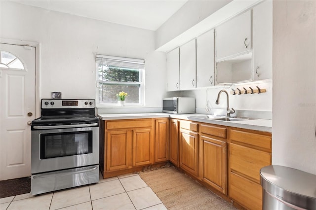 kitchen with sink, light tile patterned flooring, and appliances with stainless steel finishes