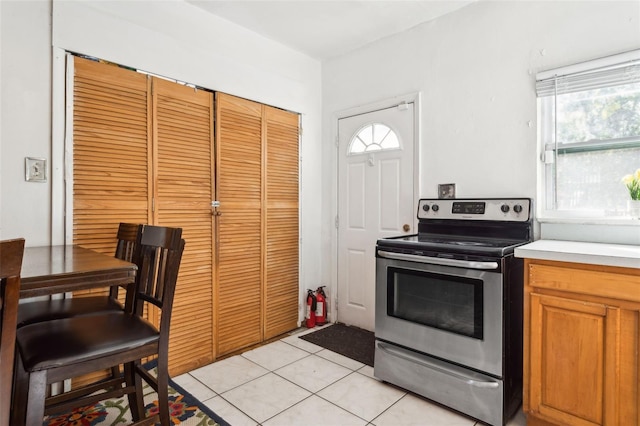 kitchen with stainless steel electric range oven and light tile patterned floors