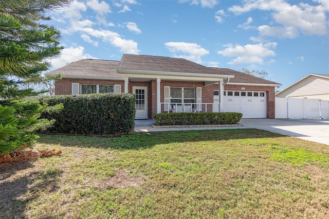 ranch-style home featuring a garage, covered porch, and a front lawn