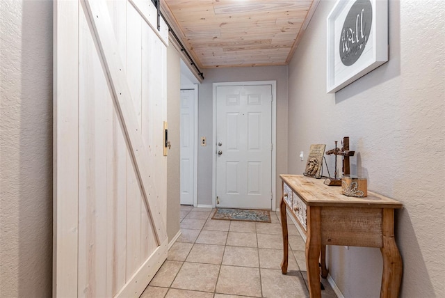 entryway featuring wood ceiling, a barn door, and light tile patterned flooring