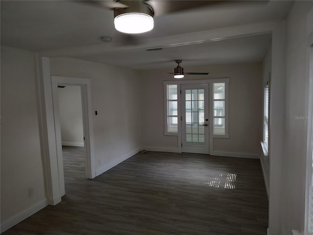 spare room with dark wood-type flooring, baseboards, and a ceiling fan