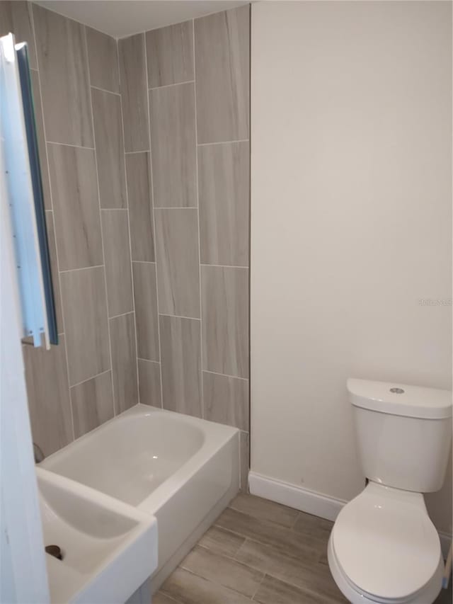 bathroom featuring toilet and baseboards