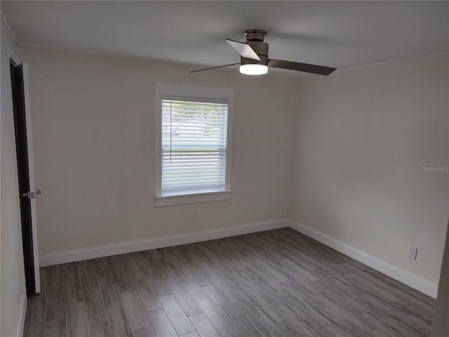 empty room featuring a ceiling fan, baseboards, and wood finished floors